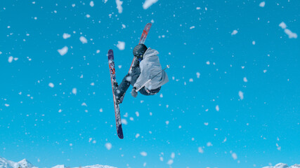 Obraz na płótnie Canvas Action shot of a male freestyle skier taking off a kicker and doing a 360 grab