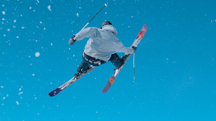 Athletic male tourist rides off a big kicker and does a spectacular 360 grab.