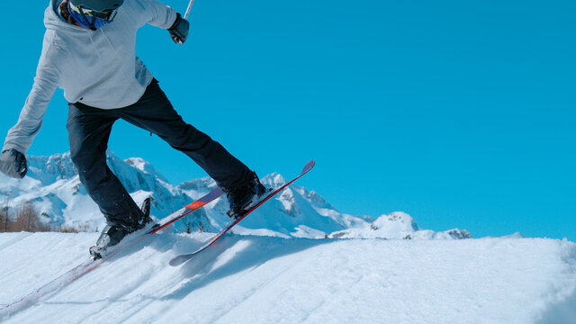 CLOSE UP: Freestyle skier rides backward and lines up to jump off a kicker.