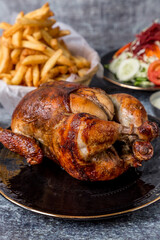 grilled chicken served with french fries and salad on gray marble