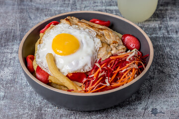 grilled chicken with salad french fries and fried egg on gray marble