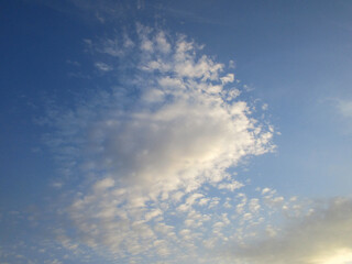 The celestial fantasy of cirrus cumulus clouds illuminated by the sun resembles a large fabulous fish with a beautiful fin and a fan-shaped tail