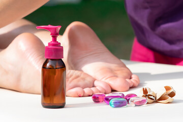 Massage of legs, female feet with bottle of oil. Close up photo of woman foot and therapist's hands...