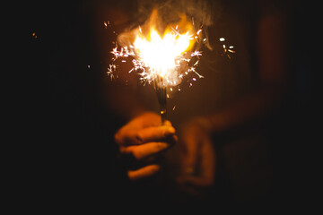 Christmas and new year eve concept image with close up of a pair of man hands taking a red fire...