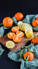 Flatlay mit Citrusfrüchten wie Orange, Zitrone, Mandarine auf Holzbrett, fruchtiges Stilleben im rustikalen Look
