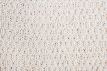 woolen background: hand-knitted sweater with thick thread close-up