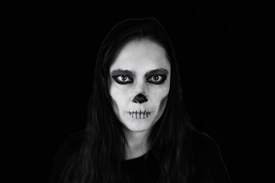 Skeleton make-up long-haired woman in the darkness, black and white