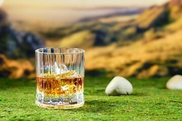Glass of strong scotch single malt whisky on mossy background