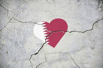 The symbol of the national flag of Qatar in the form of a heart on a cracked concrete wall.
