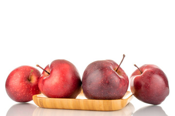 Several ripe sweet, red apples on a bamboo platter, close-up, isolated on white.