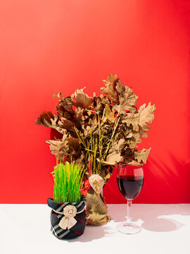 Traditional Orthodox Christmas Eve. Yule Log Or Badnjak, Burning Candle In Green Wheat And Red Wine On A Red Christmas Background. Concept Celebration Orthodox Bozic And Badnjak.Badnje Vece.