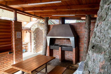 Double fireplace for barbecue with wooden table and wooden roof 