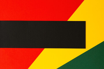 Abstract geometric background. Black horizontal stripe with copy space on red, yellow, green color background. Black History Month background