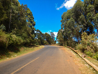 Scenic view of an empty highway against trees in Iten, Rift Valley, Kenya