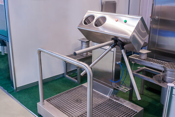 Hand hygiene station with turnstile gate and sanitizer before entering production area. Infection...