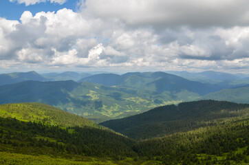 Beautiful carpathian nature scenery with mountains corered forest and village in the valley. Summer day in the Carpathians, Ukraine