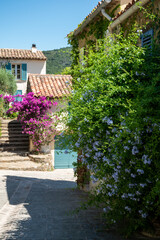 Colorful blossom of summer flowers in ancient french village Grimaud, touristic destination, Var, Provence, France