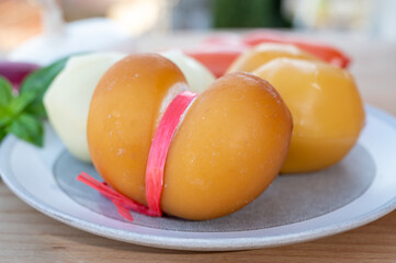 Cheese collection, variety of Italian cow milk cheese scamorza with Italian houses on background
