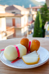 Cheese collection, variety of Italian cow milk cheese scamorza with Italian houses on background
