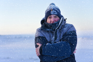 Portrait of frozen suffering guy, young handsome freezing man standing walking outdoors at winter...