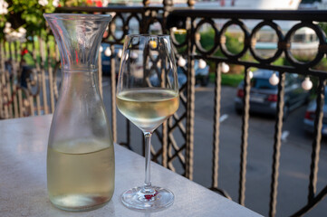 Tasting of white quality riesling wine served on outdoor terrace in Mosel wine region and old...