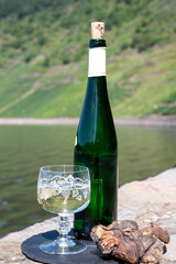Tasting of white quality riesling wine with view on steep slopes of vineyards overlooking Mosel river in sunny day
