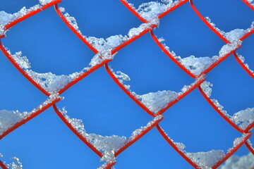 snow-covered red grid on a blue sky background