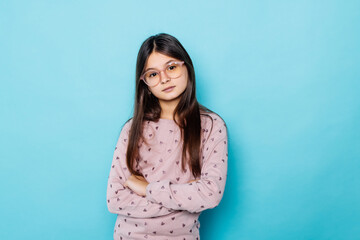 Young teen girl on a blue wall background.