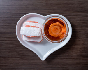 Symbols of Reims on heart shaped board - glass of rose brut champagne and rose biscuits