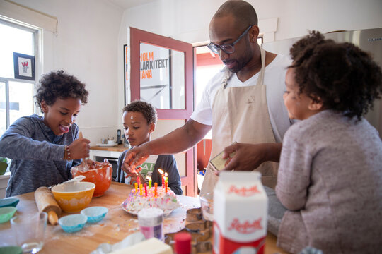 Father And Children Baking Cake In Kitchen