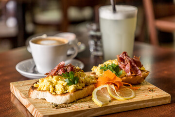 breakfast toast with egg and bacon coffee with lemonade on wood
