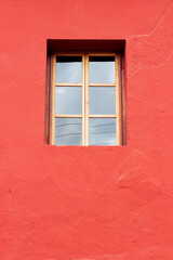 colonial window  on a red wall in antigua guatemala, vertical photo