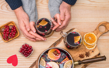 Valentines background. Couple drinking mulled wine, holding hands.