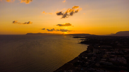 Beautiful blazing sunset landscape at black sea and orange sky above it with awesome sun golden reflection on calm waves as a background. Amazing summer sunset view on the beach