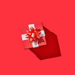 Single red gift box with ribbon on red background
