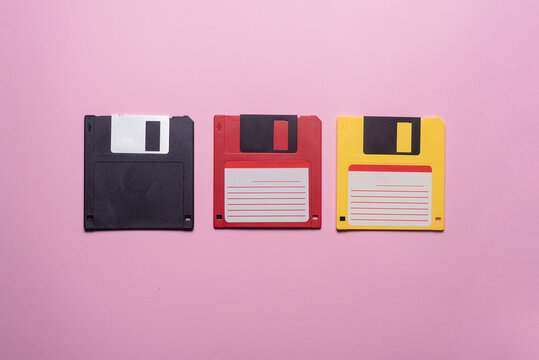 Various floppy disks on the purple flat lay background.