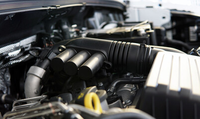 Fototapeta na wymiar The engine of a modern car. A close-up view of a portion of the intake manifold. Selected focus, background blurred.