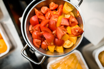 top view of saucepan with slices of colorful raw chopped vegetables
