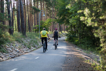 Obraz premium Man and woman ride bicycles in the forest