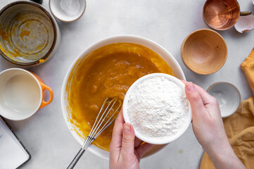 Process of cooking pumpkin cake, muffins or pumpkin dessert. Top view. Female hands. Step by step recipe.