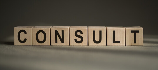 The word Consult in wooden cubes. on black background.