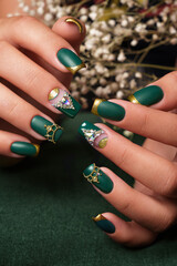 Creative green design of nails on female hands. Art manicure.