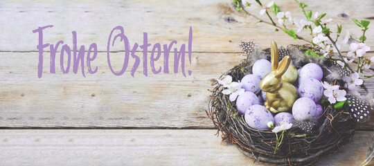 Easter greeting card with German text - Frohe Ostern - eggs in a basket on a wooden table - easter...