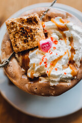 Valentine's messy hot chocolate with toasted marshmallow,  whipped cream, caramel, sprinkles and pink conversation heart Ooh La La