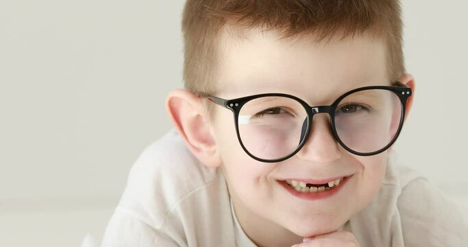 Portrait child boy With Glasses Looking at Camera. Laughs Happily toothless kid with Glasses Looking at Camera. Close Up. Inquisitive preschool boy Portrait. Face Funny Contemplative.4k