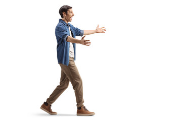 Full length profile shot of an excited young man walking with arms wide open
