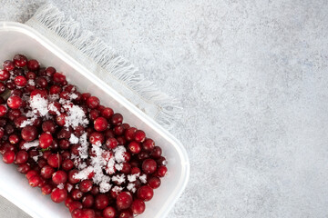 Frozen berries covered with hoarfrost. Frozen cranberry on grey background.