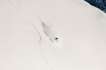 view of mountain slope and brave skier sliding down on it. Freeride skiing concept