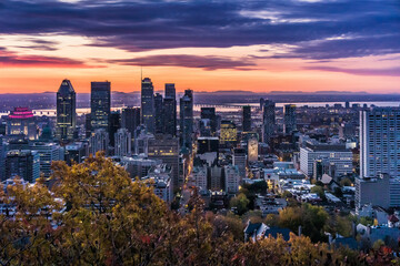 Fototapeta na wymiar Sunrise over the skyline of Montreal, watched from the Kondiaronk Belvedere in Mont Royal Park.