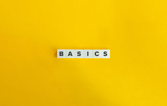 Basics Word on Block Letter Tiles on bright orange background. Minimal aesthetics.